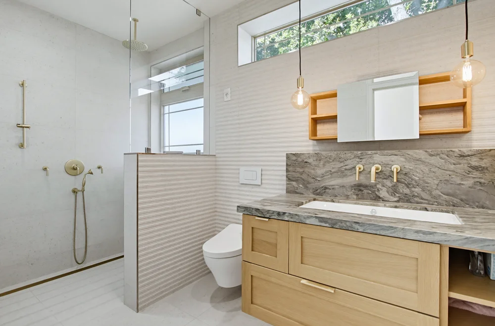 ADU bathroom with curbless shower and brass fixtures